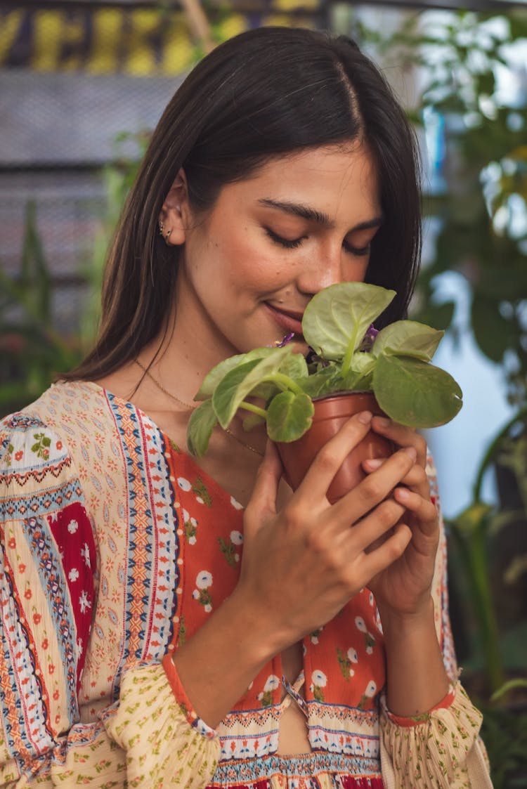 A Woman Holding A Potted Plant