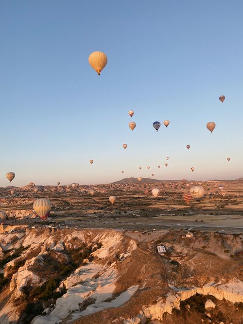 Free A breathtaking view of hot air balloons soaring over Cappadocia during sunrise in Göreme, Turkey. Stock Photo
