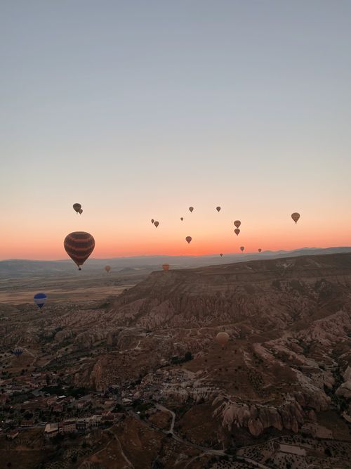 Free Stunning view of hot air balloons floating over Cappadocia's landscape at sunrise. Stock Photo