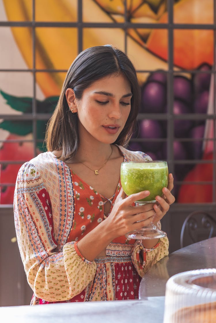 A Woman Holding A Glass Of Juice