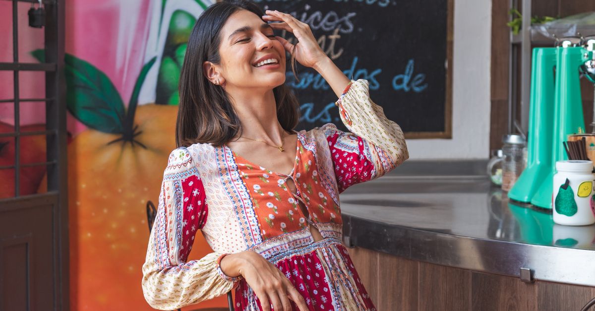 woman in a colorful, eclectic outfit smiling genuinely
