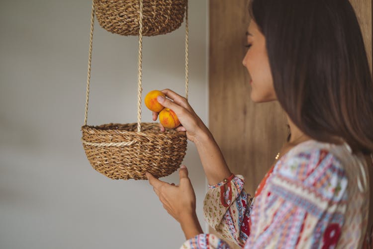 Woman Putting Apricots In Basket