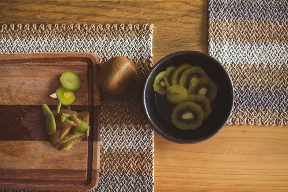 Frutas y verduras frescas: acedera encurtida en frasco y kiwis maduros en bandeja