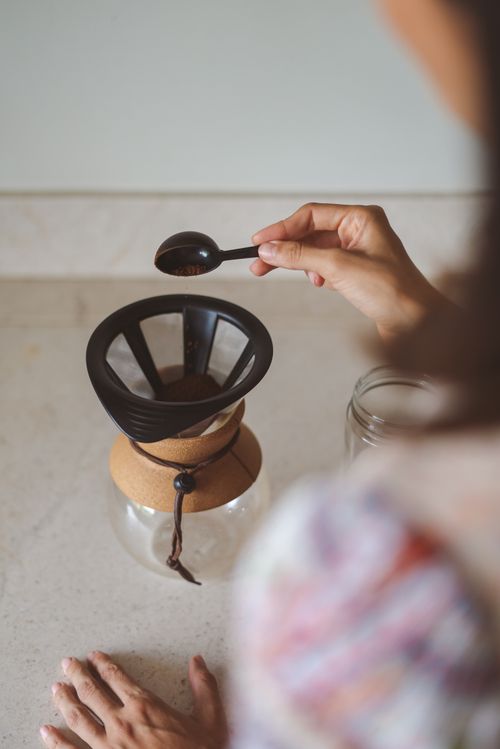 Free Overhead view of hands preparing drip coffee using a manual coffee maker. Stock Photo