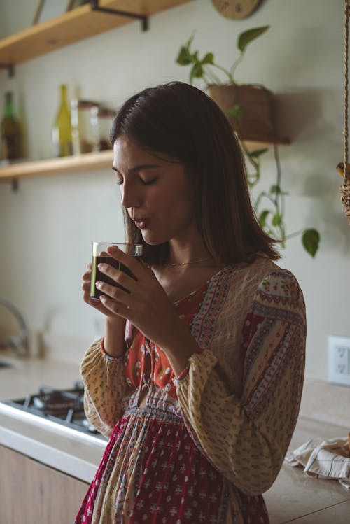 Woman Blowing Into a Coffee Cup 