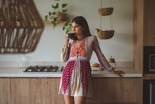 A Woman in Long Sleeve Dress Drinking a Coffee