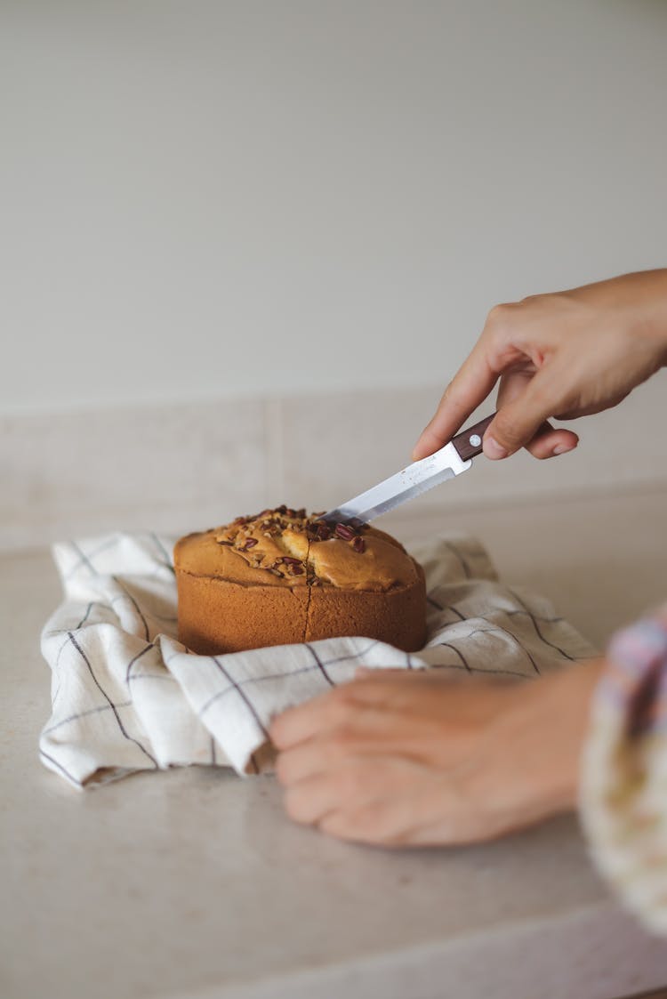 Person Slicing A Bread