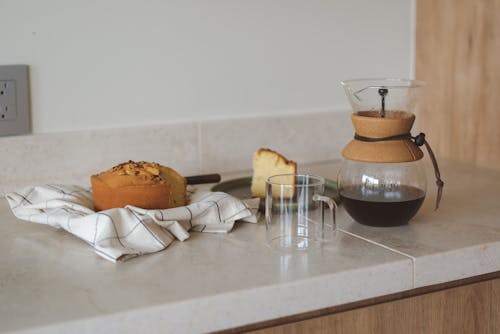 Free Drip Coffee Pitcher and a Cake on the Kitchen Counter Stock Photo