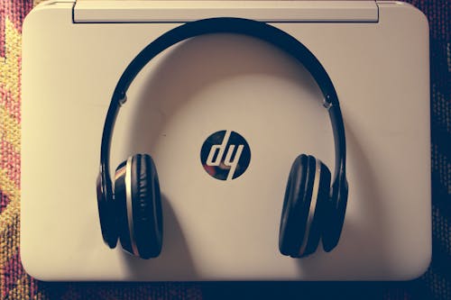 Black Wireless Headphone Near White Hp Laptop