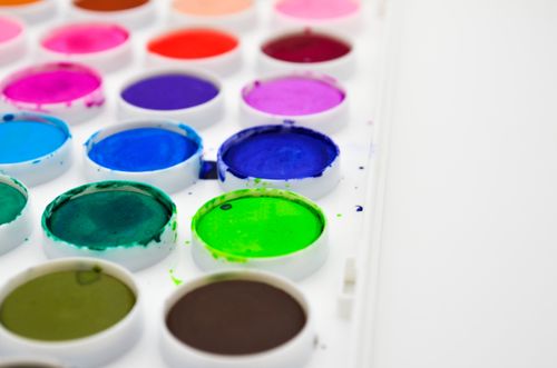 Free A vibrant close-up of watercolor paints in a white palette, showcasing a spectrum of bright colors. Stock Photo
