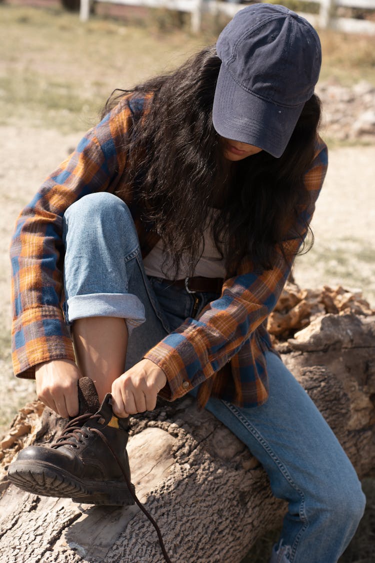 Woman In Plaid Shirt Putting On A Shoe