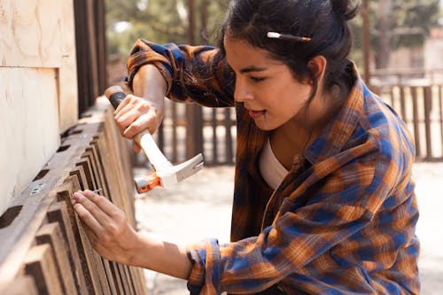 Woman Fixing Wooden Fence