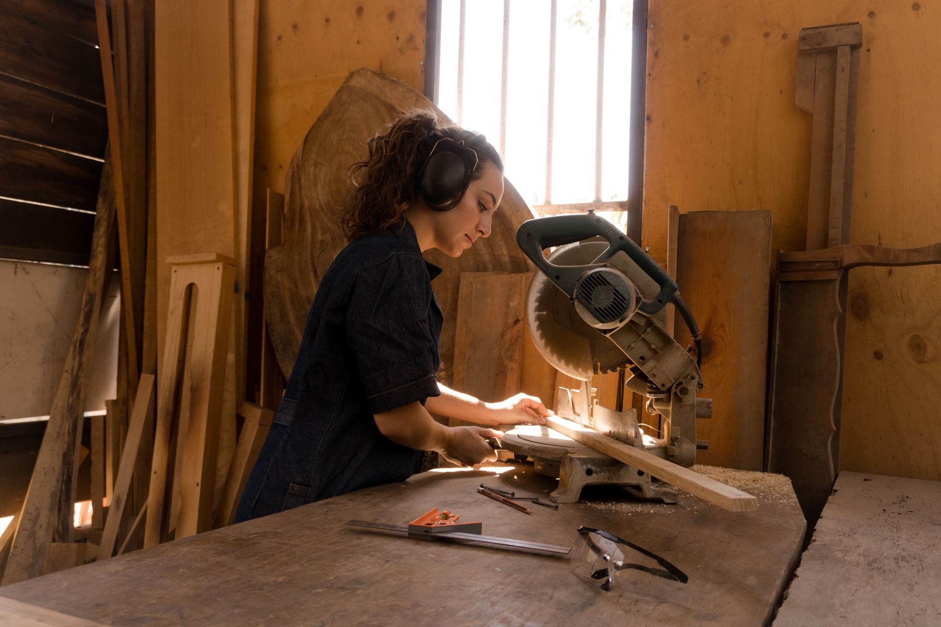 Handywoman grinding a Wood Plank