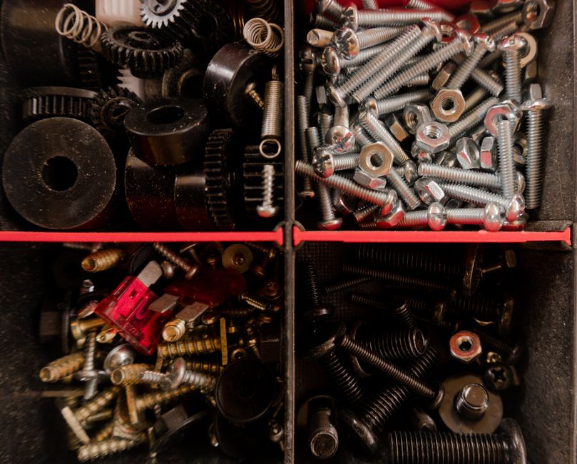 Close-up of various screws and bolts organized in a toolbox compartment.