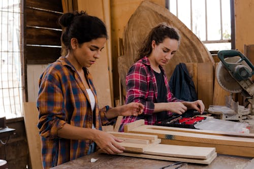 Women in Plaid Dress Shirts Working Together in a Workshop