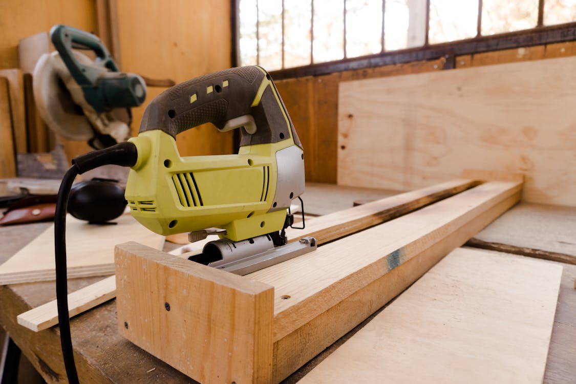 Free Yellow and Black Power Tool on a Wood Plank Stock Photo