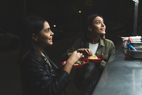Women Eating Tacos at a Taco Stand