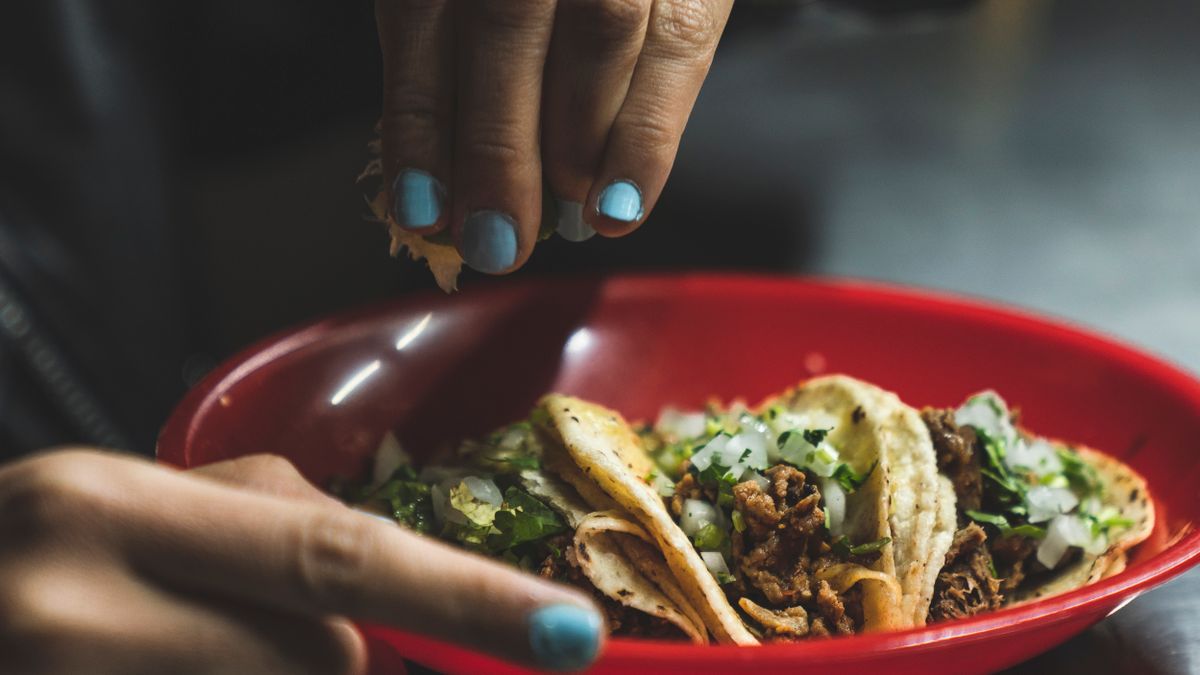 Plate of Mexican tacos al pastor with lime and cilantro