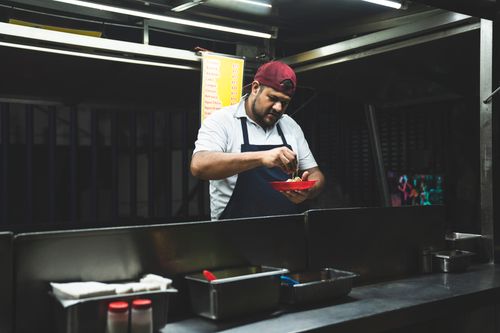 Free Taco vendor preparing fresh Mexican tacos at a nighttime street food stand. Stock Photo