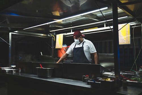 Free Man Wearing an Apron Cooking at a Taco Stand Stock Photo