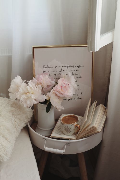 Free A serene bedside scene with coffee, pink peonies, and an open book for a cozy ambiance. Stock Photo