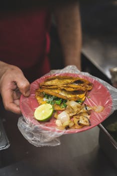 Close-up of authentic Mexican street tacos served with lime on a plate.