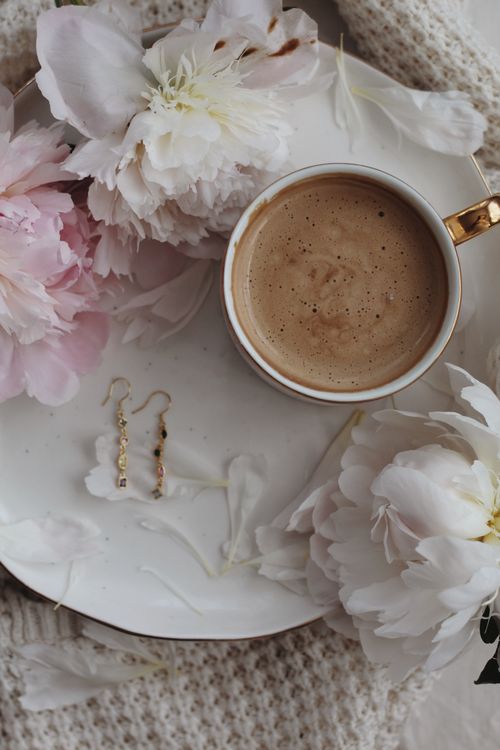 Free A beautifully arranged flat lay with coffee, peonies, and earrings on a white plate. Stock Photo