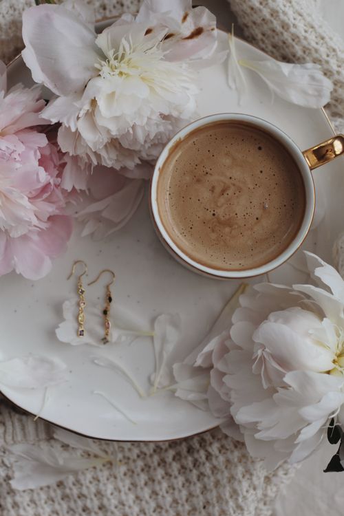 Free Stylish flat lay of coffee with pink flowers and earrings on a white plate. Stock Photo