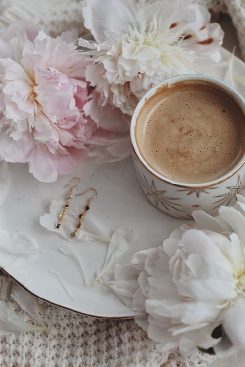 Free A beautifully composed flat lay of a coffee cup with delicate pink and white flowers. Stock Photo