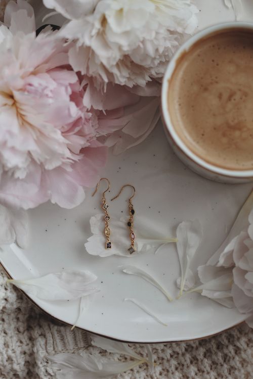 Free Delicate earrings styled with a cup of coffee and peonies for a cozy, elegant feel. Stock Photo