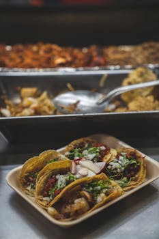 Delicious tacos filled with savory ingredients and fresh garnishes on a rustic tray.