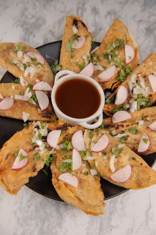 Free A plate of Mexican tacos garnished with radishes and served with a rich dipping sauce. Stock Photo