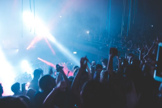 Vibrant scene of a lively nightclub party with a crowd enjoying music under dramatic lights.