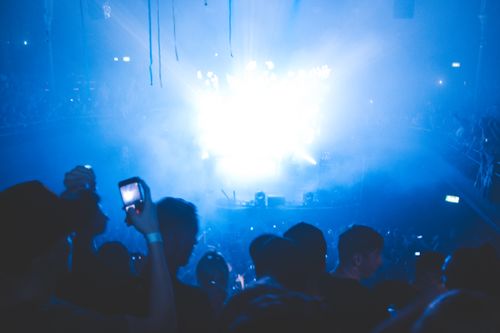 Free Dynamic concert scene with a lively crowd and colorful stage lights capturing the essence of live music events. Stock Photo