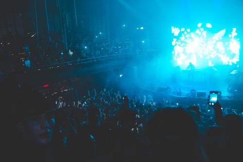 Free Vibrant nightclub concert scene with a lively crowd and dazzling blue lights in a packed venue. Stock Photo