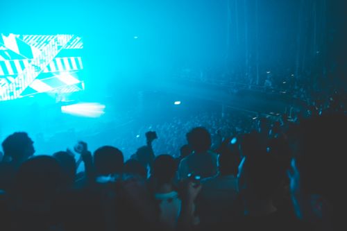 Free A lively crowd enjoys a concert with vibrant lights and energetic atmosphere in a nightclub. Stock Photo