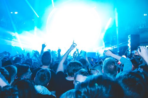 Free Energetic crowd enjoying a vibrant live concert with dazzling lights and lively atmosphere. Stock Photo
