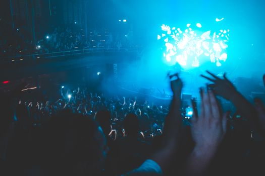 Energetic nightclub scene with a lively crowd enjoying a live DJ performance.