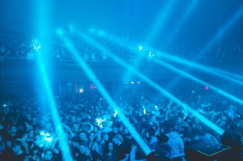 Free Energetic crowd enjoying a lively party night with dazzling blue laser lights. Stock Photo