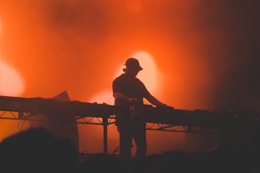 A DJ silhouette creating an energetic atmosphere with vibrant red lighting at a nightclub event.