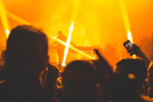 Dynamic nightclub atmosphere featuring DJ, silhouettes, and vibrant light effects.