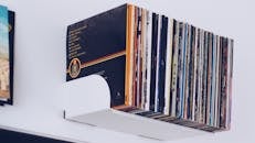 白色书架上整齐地放着一堆极简主义的黑胶唱片