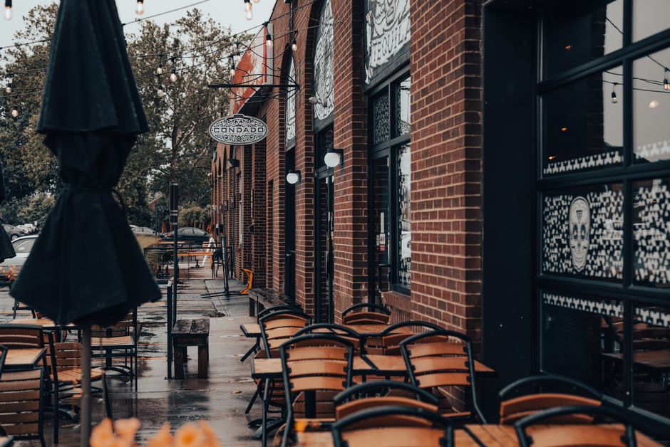 Charming brick-walled outdoor cafe with tables and chairs on an overcast day.
