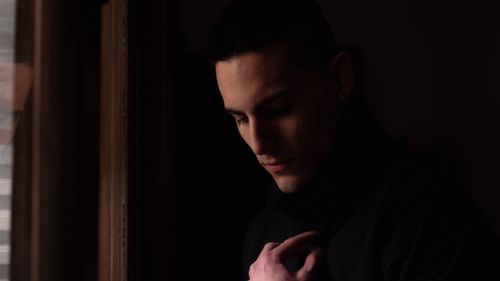 Free A contemplative man in Buenos Aires, captured in a dimly lit setting, creating a dramatic mood. Stock Photo