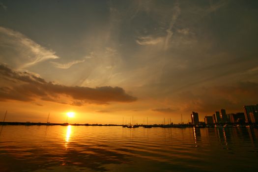 Breathtaking sunset over Manila Bay with a stunning city skyline silhouette reflecting on tranquil waters.