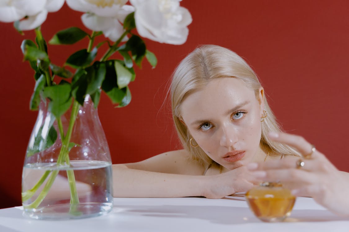 Beautiful Woman at Table with Flower Vase