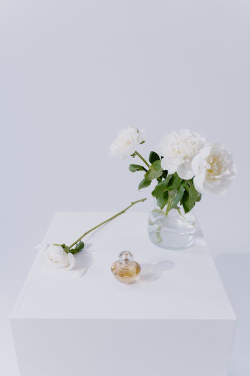 A White Flowers Near the Perfume Bottle