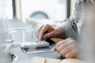 A hand uses a digital scale with a beaker in a laboratory setting. Perfect for scientific and educational content.