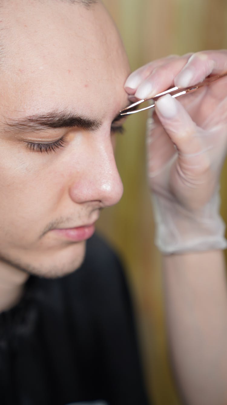 Young Man Having His Eyebrow Plucked