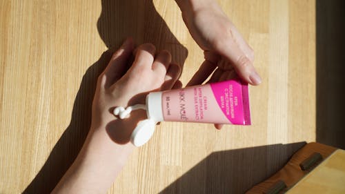 Free Person Holding Pink and White Tube Cream Stock Photo